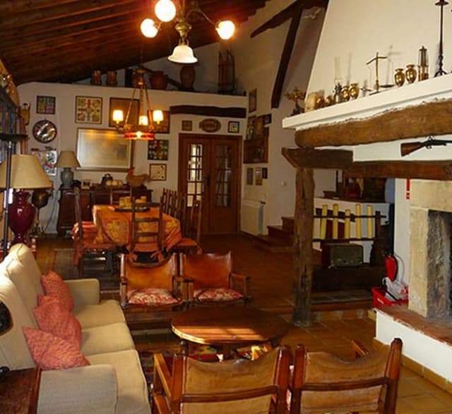 Salón principal con vigas de madera y chimenea